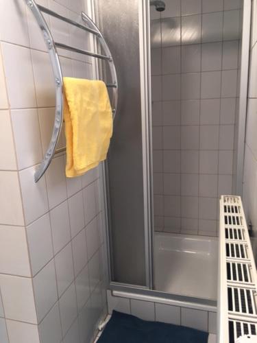 ein Bad mit einer Dusche und einem gelben Handtuch in der Unterkunft Ferienwohnung Beate Hassler in Berg im Drautal