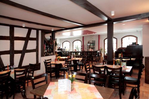 a restaurant with tables and chairs and a piano at Pension La Cascina in Tuttlingen