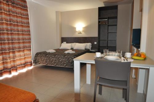 a hotel room with a bed and a table and a room at Aparthotel Safari in Calella