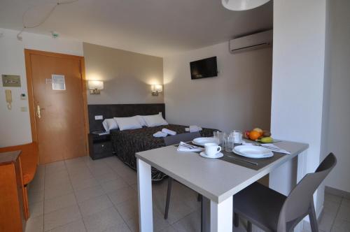a hotel room with a table and a bed at Aparthotel Safari in Calella