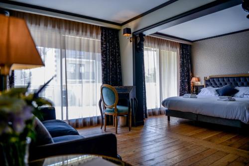 アルカションにあるHôtel Villa-Lamartineのベッド、デスク、窓が備わるホテルルームです。