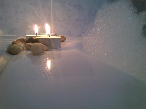 a candle sitting in a bath tub with some lights at Hotel Anatolia in Ano Mera