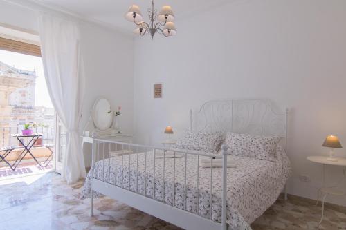 シラクーサにあるMaison Ortigiaの白いベッドルーム(ベッド1台、バルコニー付)