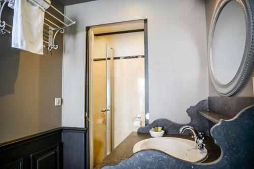 a bathroom with a sink and a mirror at Hôtel Villa-Lamartine in Arcachon