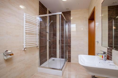 uma casa de banho com uma cabina de duche em vidro e um lavatório. em Mùlk Chëcz Kaszëbsko em Myszewko