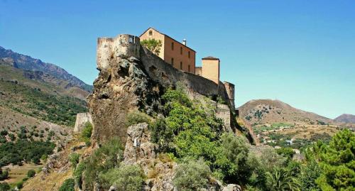 a castle on the top of a mountain at Les Bergeries "Le figuier" in Omessa