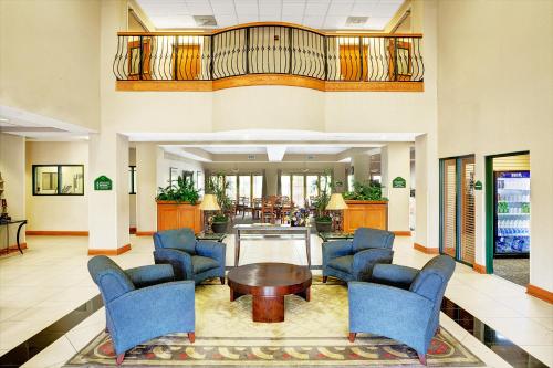 a lobby with blue chairs and a table at Wingate by Wyndham Atlanta Fairburn in Fairburn