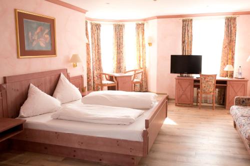 um quarto de hotel com uma cama e uma televisão em Hotel Hirsch em Rothenberg