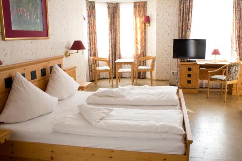 a bedroom with two beds and a table and a desk at Hotel Hirsch in Rothenberg