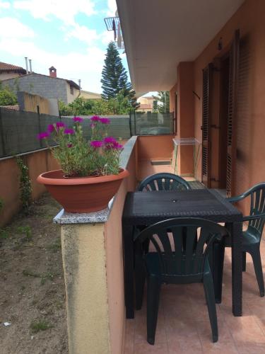a patio with a table and chairs and a potted plant at Gaia House in Oristano
