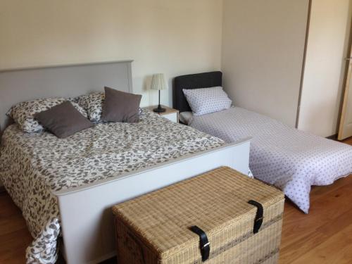 um quarto com 2 camas e um repousa-pés em Un petit nid a Honfleur em Honfleur