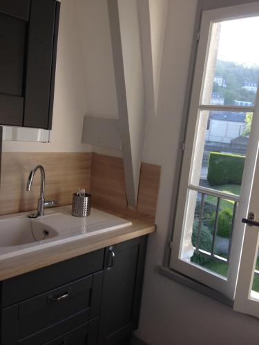 uma cozinha com um lavatório e uma janela em Un petit nid a Honfleur em Honfleur