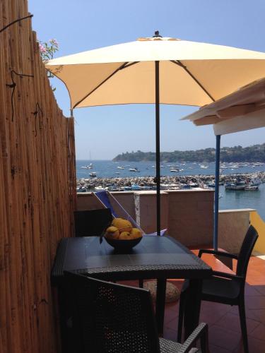a bowl of fruit on a table with an umbrella at La Casa di Titina in Procida