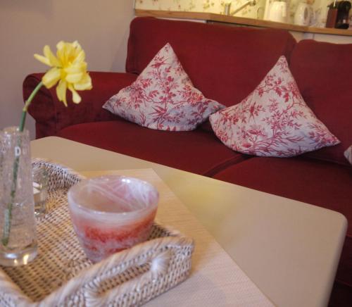 a red couch with pillows on it with a table at Inselferien Micheel in Burg auf Fehmarn