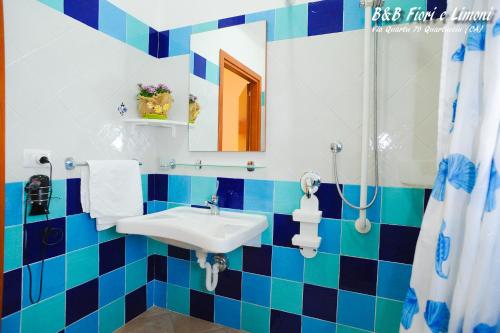 a blue and white bathroom with a sink and a shower at Fiori e Limoni in Quartucciu