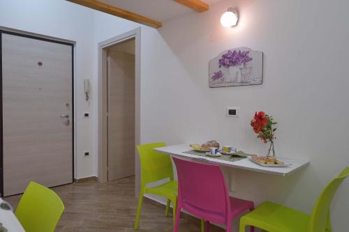 恩佩多克萊港的住宿－Cavaliere Costa，一间配备有桌子和五颜六色椅子的用餐室