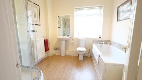 a bathroom with a tub and a toilet and a sink at Marvene in Thornaby on Tees