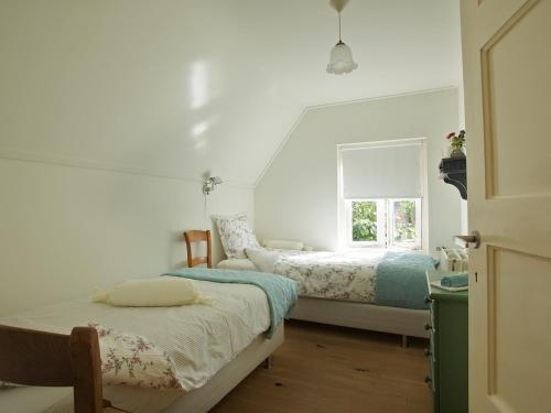 een slaapkamer met 2 bedden en een raam bij Bed and Breakfast Millingen aan de Rijn in Millingen aan de Rijn