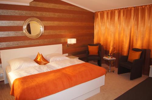 1 dormitorio con cama, espejo y silla en Hotel Christine en Füssen