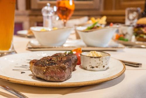 a piece of steak on a plate on a table at Hotel Schiller in Olching