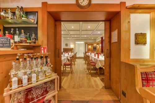 a restaurant with a bar with tables and chairs at Hotel Schiller in Olching
