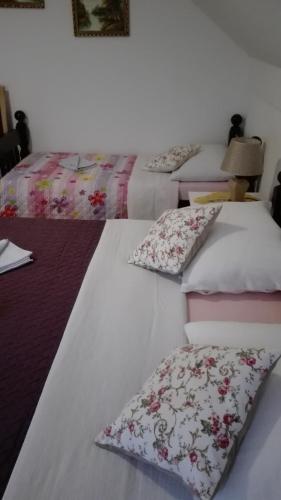 three beds in a room with pillows on them at Guest House Adrijana in Seliste Dreznicko