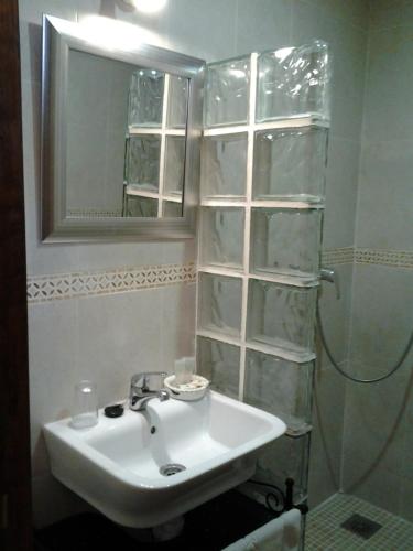 a bathroom with a sink and a mirror and a shower at Hotel Rural Grado del Pico in Grado del Pico