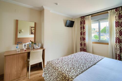 a bedroom with a bed and a desk and a window at Pontus Veteris in Sanxenxo