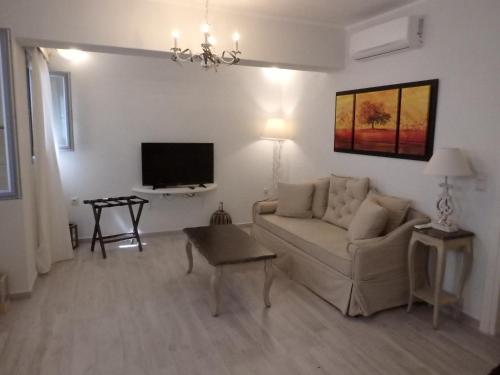 a living room with a couch and a tv at Naxos Illusion Nikos Verikokos in Naxos Chora