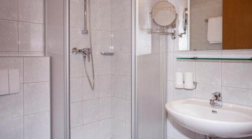 a white bathroom with a shower and a sink at Apart Anja in Ischgl