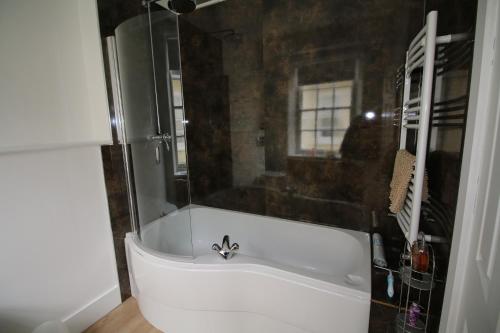 a bathroom with a bath tub with a sink at Prince Hill House in Devizes