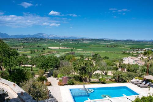 an outdoor swimming pool with a view of a golf course at Casa Font i Roig in Maria de la Salut