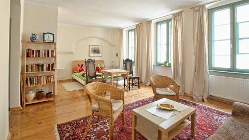 a living room with a table and chairs and a living room with a tablektop at Haus Buchheim - Pension am Schloss in Bautzen