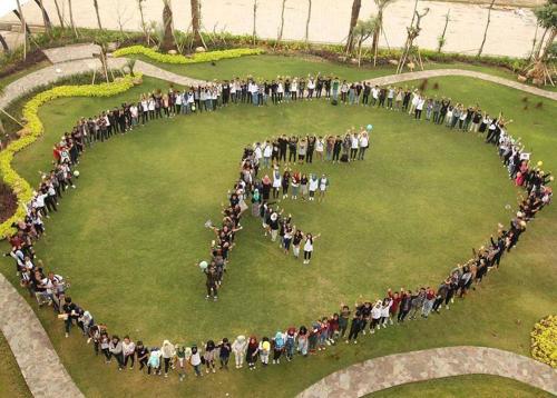 a large group of people standing in a circle at MaxOneHotels at Resort Makassar in Makassar