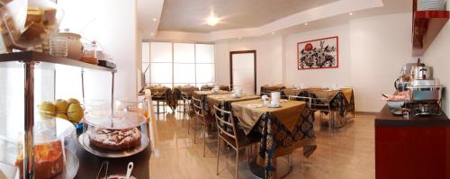 a restaurant with tables and chairs in a room at Hotel Garnì Corallo in Nago-Torbole