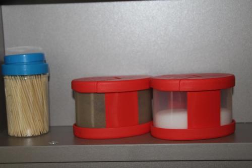 two red containers sitting on top of a shelf at Apartment FALVIG inkl. Küche in Bad Schonborn