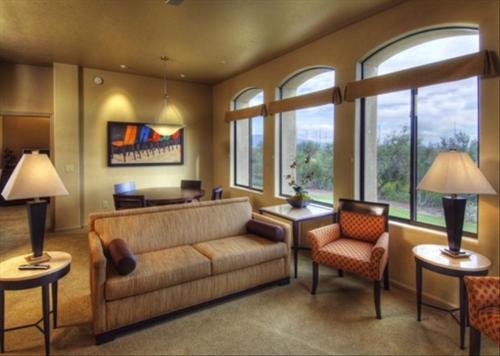 a living room with a couch and chairs and windows at Casitas at Sabino Springs in Tucson