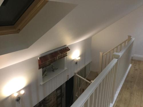 a staircase in a house with white walls and lights at Morgan's Rest in Pickering