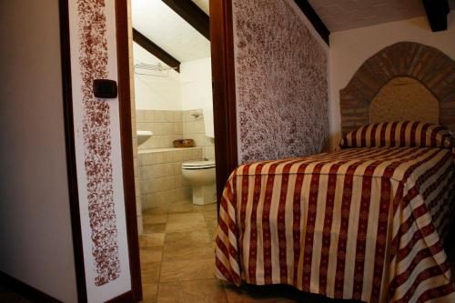 a bedroom with a bed and a bathroom with a toilet at Soprattutto in Montalbano Ionico