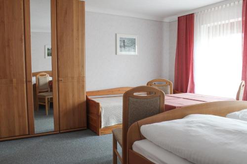 メルビッシュ・アム・ゼーにあるPension Binderのベッド2台と鏡が備わるホテルルームです。