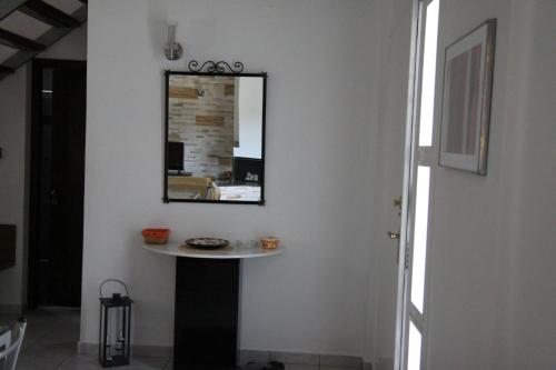 a mirror on a wall with a table in a room at Villada in Margariti
