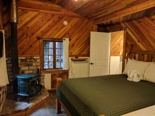 a bedroom with a bed and a stove in a cabin at Emerald Forest Cabins in Trinidad