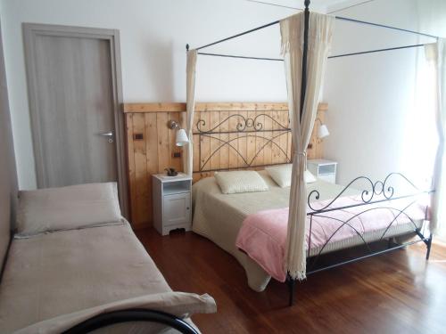 sypialnia z łóżkiem z baldachimem i łóżkiem sidx sidx sidx sidx w obiekcie Antica Trattoria del Boden w mieście Ornavasso