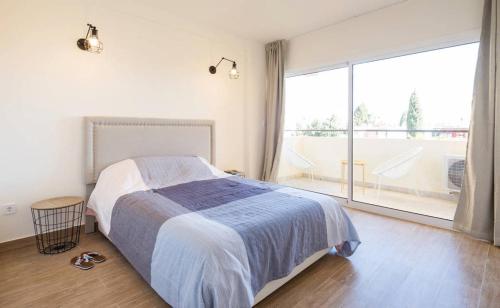 a bedroom with a bed and a large window at Apartment Club Playa Flores in Torremolinos