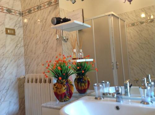 a bathroom with a sink and two vases with flowers at La Vecchia Quercia in Pergine Valdarno