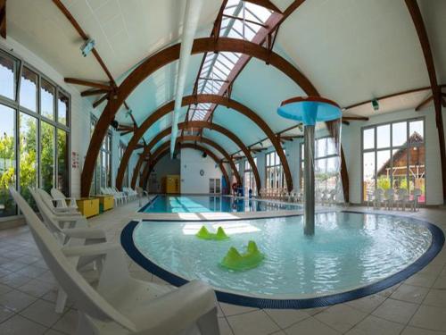 une piscine dans une salle de sport avec des chaises et un parc aquatique dans l'établissement GH Vacances La Réserve, à Gastes