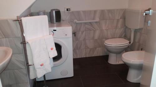 a small bathroom with a washing machine and a toilet at Reusia Holiday Home in Ragusa