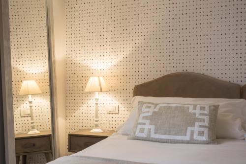 a bedroom with a bed with a white pillow and two lamps at Locanda Don Serafino Historical Boutique Hotel in Ragusa
