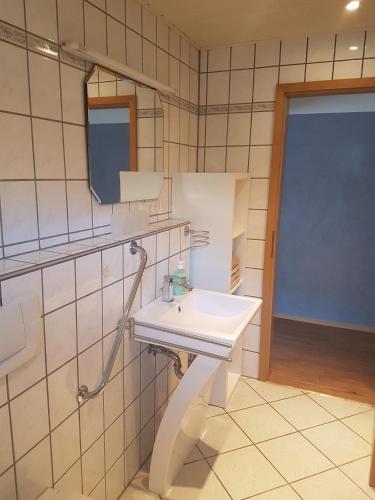 カッペル・グラーフェンハウゼンにあるFerienwohnung Regenbogenのバスルーム(白い洗面台、鏡付)