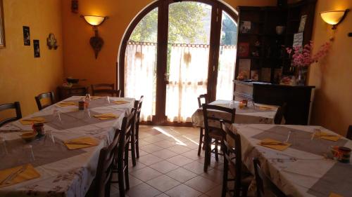 ein Esszimmer mit Tischen und Stühlen mit weißem Tischtuch in der Unterkunft Le Bottesele in San Zeno di Montagna